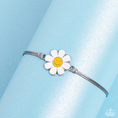 Held together and centered within soft gray cording, a single daisy charm rests. Featuring a silver smiley face in its yellow center, this single flower provides a fashionably, minimalistic statement around the wrist. Features an adjustable sliding knot closure.  Sold as one individual bracelet.