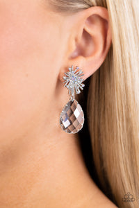 An explosion of radiating silver bars is topped with a sprinkle of iridescent rhinestones, creating a stellar anchoring point. Swinging below the starburst, an oversized, clear teardrop with a light-catching, faceted surface is wrapped in a textured border of silver, adding stunning dimension and refinement to the cosmic combination. Earring attaches to a standard post fitting. Due to its prismatic palette, color may vary. Sold as one pair of post earrings.