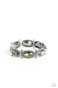 Glittery oil spill gems are pressed into silver studded, marquise-cut frames, titled on its side. Separated by dainty hematite rhinestones encased in sleek silver frames, the sparkly collection is threaded along elastic stretchy bands for a dramatic look around the wrist. Due to its prismatic palette, color may vary.  Sold as one individual bracelet.