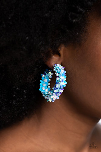 A floral explosion, encompassing the entirety of a thick silver hoop, features reflective light blue flowers dotted with dainty pearl centers for a dreamy, whimsicality below the ear. Earring attaches to a standard post fitting. Hoop measures approximately 1 1/2
