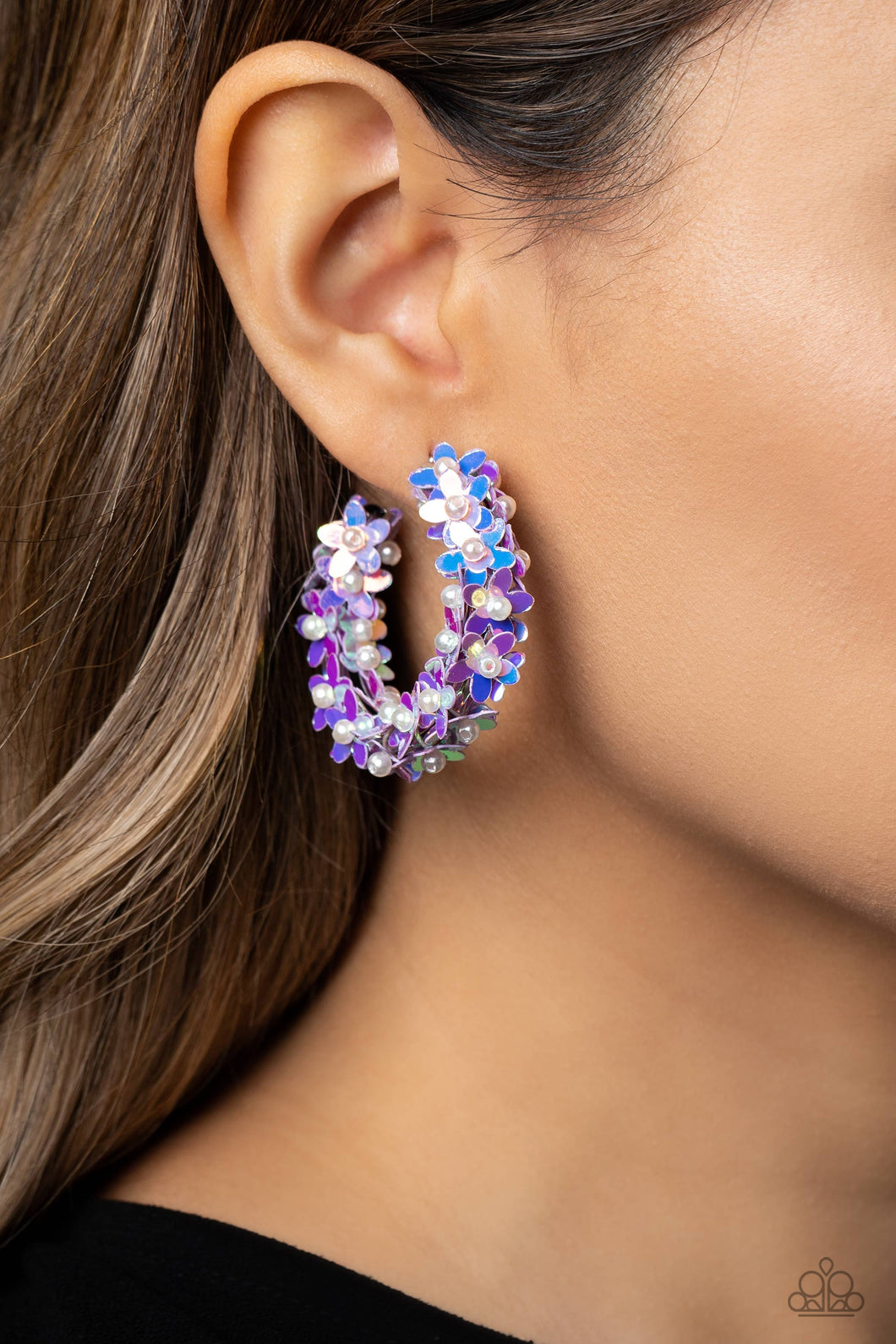 A floral explosion, encompassing the entirety of a thick silver hoop, features reflective lavender flowers dotted with dainty pearl centers for a dreamy, whimsicality below the ear. Earring attaches to a standard post fitting. Hoop measures approximately 1 1/2