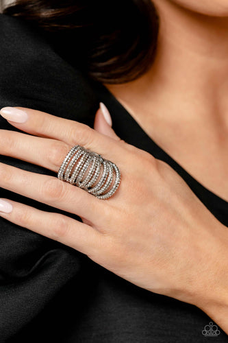 An elongated silver frame, lined with dainty white rhinestones, creates the illusion of endless sparkle as it stacks up the finger. Encrusted in two rows across each silver band as it arcs across the finger, the high sheen finish creates a stunning backdrop for the rhinestones, allowing the skin to peek through the airy bands for a whimsical finish. Features a stretchy band for a flexible fit.  Sold as one individual ring.