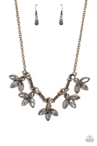 ﻿Featuring smoldering marquise style cuts, oversized smoky gems fan out from an interconnected, circular smoky rhinestone display. Separating the dauntless florals, airy brass ovals, stamped with a dot motif, create additional eye-catching sheen. Features an adjustable clasp closure.  Sold as one individual necklace. Includes one pair of matching earrings.
