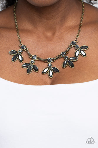 ﻿Featuring smoldering marquise style cuts, oversized smoky gems fan out from an interconnected, circular smoky rhinestone display. Separating the dauntless florals, airy brass ovals, stamped with a dot motif, create additional eye-catching sheen. Features an adjustable clasp closure.  Sold as one individual necklace. Includes one pair of matching earrings.