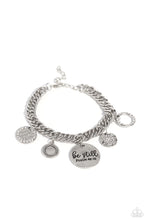 Load image into Gallery viewer, A collection of refined charms add some texture and shimmer to this monochromatic mash-up. An oversized, hammered disc is stamped with the phrase &quot;be still&quot; with the scripture reference &quot;Psalm 48:10&quot; listed underneath it. A smaller, hammered disc with a sprinkle of white rhinestones in its center and a silver disc featuring a scalloped ring in its center glide next to the oversized silver disc. A silver ring with serrated texture, and a silver disc with hammering and ring of white rhinestones glimmers. 
