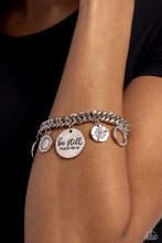 Load image into Gallery viewer, A collection of refined charms add some texture and shimmer to this monochromatic mash-up. An oversized, hammered disc is stamped with the phrase &quot;be still&quot; with the scripture reference &quot;Psalm 48:10&quot; listed underneath it. A smaller, hammered disc with a sprinkle of white rhinestones in its center and a silver disc featuring a scalloped ring in its center glide next to the oversized silver disc. A silver ring with serrated texture, and a silver disc with hammering and ring of white rhinestones glimmers.
