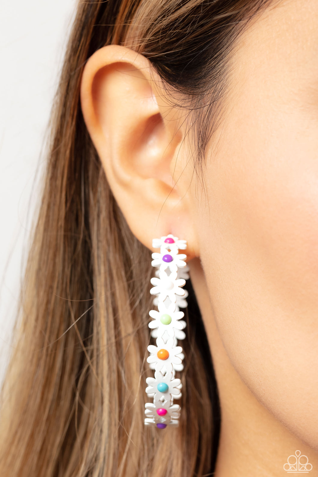 A dainty collection of white daisies with white, orange, green, blue, pink, and purple centers blooms into a free-spirited hoop around the ear. Earring attaches to a standard post fitting. Hoop measures approximately 2