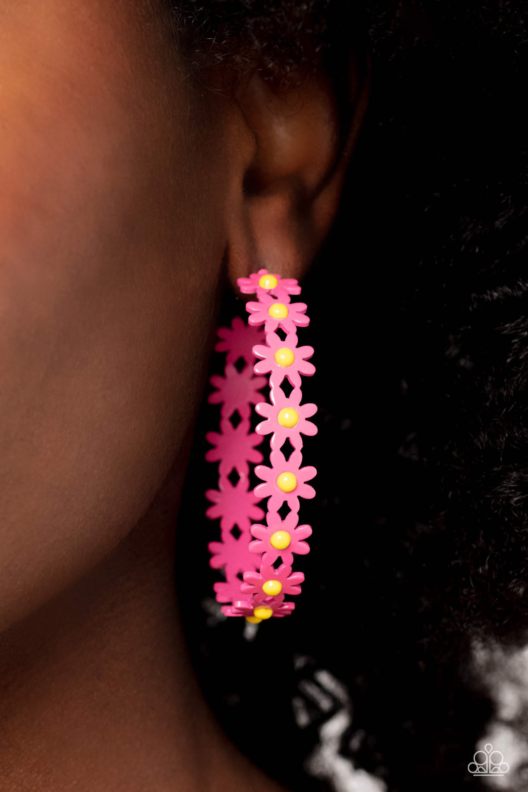 A dainty collection of hot pink daisies with yellow centers blooms into a free-spirited hoop around the ear. Earring attaches to a standard post fitting. Hoop measures approximately 2