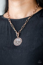 Load image into Gallery viewer, Embossed in a whimsical rosebud pattern, a shimmery copper frame swings below the collar for a casual look. Features a toggle closure. Sold as one individual necklace. Includes one pair of matching earrings.

