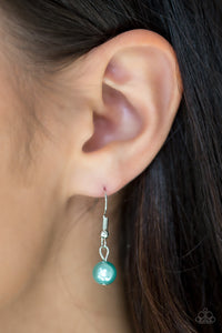 Green pearl dangling from a silver fish hook earring.