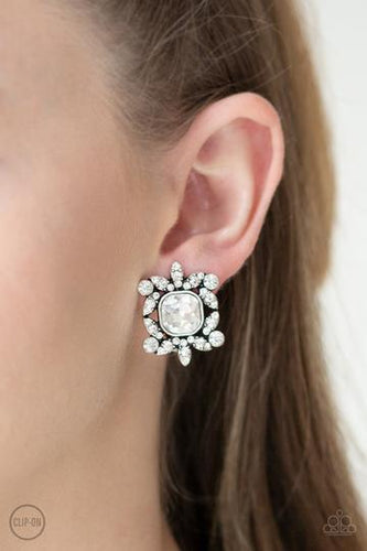 A collection of glassy white rhinestones are sprinkled across dainty silver frames, creating regal foliage around a white gem center. Earring attaches to a standard clip-on fitting.  Sold as one pair of clip-on earrings.