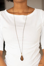 Load image into Gallery viewer, Infused with a topaz rhinestone encrusted fitting, an asymmetrical brown moonstone swings from the bottom of an elongated brass chain for a whimsical look. Features an adjustable clasp closure. Sold as one individual necklace. Includes one pair of matching earrings.
