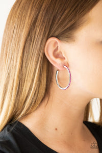 Encrusted in glassy pink rhinestones, a textured silver hoop curls around the ear for a refined look. Earring attaches to a standard post fitting. Hoop measures 1 3/4" in diameter.  Sold as one pair of hoop earrings.