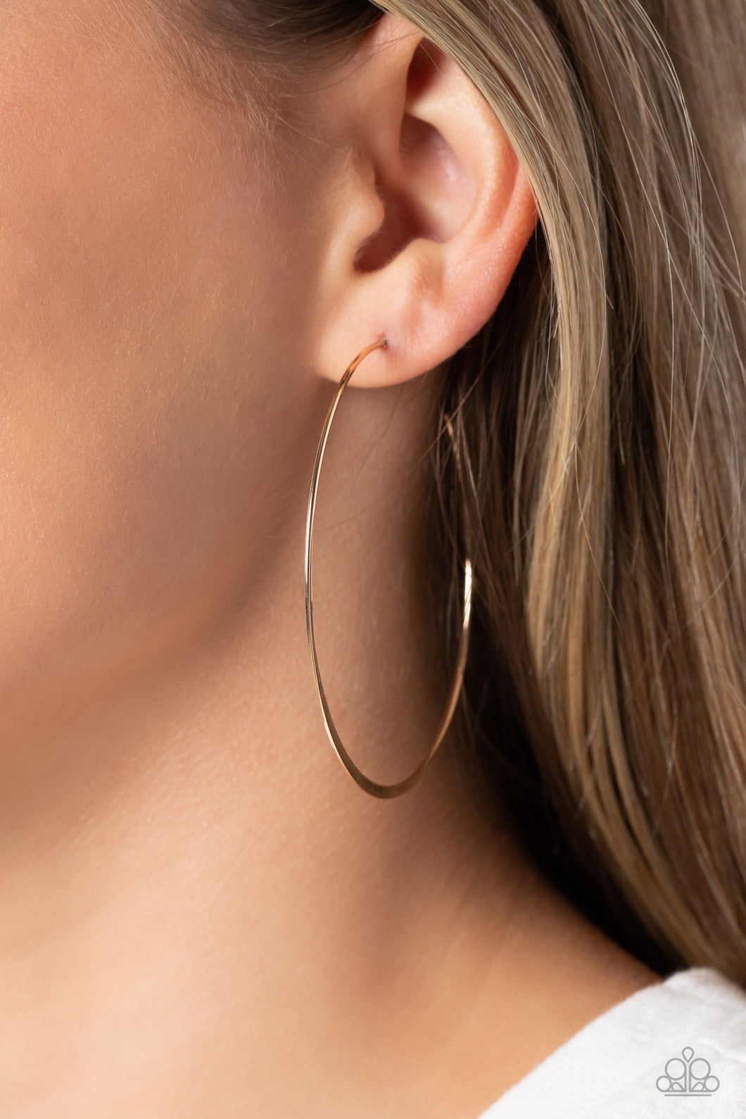 Featuring a high-sheen, a slightly flared, thin smooth gold bar curves into an oversized hoop resulting in a basic staple piece. Earring attaches to a standard post fitting. Hoop measures approximately 2 1/2