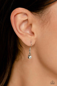 Small rhinestone hanging from a silver fish hook earring.