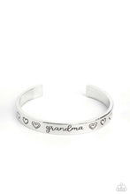 Load image into Gallery viewer, Brushed in a polished sheen, a skinny silver bar curls around the wrist, creating a rustic cuff. Featuring a heart motif, the skinny cuff is engraved with the word “grandma” with various styles of hearts framing the word for an inspiring, heartfelt finish.  Sold as one individual bracelet.
