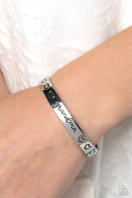 Load image into Gallery viewer, Brushed in a polished sheen, a skinny silver bar curls around the wrist, creating a rustic cuff. Featuring a heart motif, the skinny cuff is engraved with the word “grandma” with various styles of hearts framing the word for an inspiring, heartfelt finish.  Sold as one individual bracelet.
