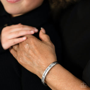 Brushed in a polished sheen, a skinny silver bar curls around the wrist, creating a rustic cuff. Featuring a heart motif, the skinny cuff is engraved with the word “grandma” with various styles of hearts framing the word for an inspiring, heartfelt finish.  Sold as one individual bracelet.