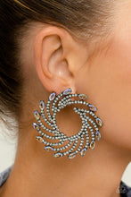 Load image into Gallery viewer, Shimmery strands of silver spin out from an airy center, creating an exaggerated firework-like display at the ear. An explosion of dainty white rhinestones lines the swirls and curves of the shimmery display leading the eye to the collection of colorfully reflective marquise-cut gems at its ends. Each colorfully reflective marquise-cut gem curls around the ear in a clock-like manner, creating additional eye-catching dimension.
