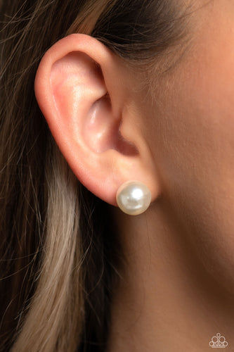 An oversized white pearl, stands out against the ear adding a timeless twist to a basic staple piece perfect for layering. Earring attaches to a standard post fitting.  Sold as one pair of post earrings.