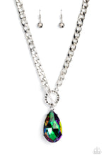 Load image into Gallery viewer, Featuring an elegant lariat closure, an oversized, faceted, stellar UV shimmery teardrop gem, encased in an elevated pronged silver frame cascades from the bottom of a silver curb chain in a whimsical fashion. Dainty hematite rhinestones are encrusted along the ring as the lariat closure loops through for a touch of edgy shimmer to the exaggerated sparkly design. Due to its prismatic palette, color may vary.  Sold as one individual necklace. Includes one pair of matching earrings.
