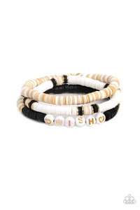 Varying in shades, tan, black, and white clay discs pair with shiny gold disc beads and accents creating layers across the wrist. Featured on one of the bracelets, white beads stamped with gold lettering spell out the word "wish," while gold heart silhouettes stamped in the same white beads frame the inspirational phrase for a wistful finish.  Sold as one set of three bracelets.