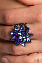Load image into Gallery viewer, Glittery blue iridescent rhinestone petals stack into a glamorous floral frame atop the finger, creating a blinding centerpiece. Features a stretchy band for a flexible fit. Due to its prismatic palette, color may vary.  Sold as one individual ring.
