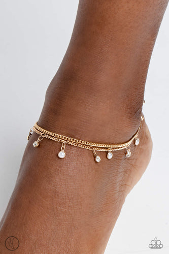 A fringe of dainty pearls and white gems pressed into sleek gold frames wraps around the ankle on a dainty gold chain, creating a glittery, oceanic statement. A second dainty gold chain adds a high-sheen layer for a refined finish. Features an adjustable clasp closure.  Sold as one individual anklet.