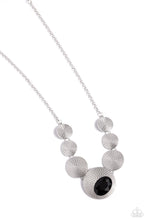 Load image into Gallery viewer, Embossed in an elongated dotted motif, a rustic collection of silver discs in varying sizes ruggedly links below the collar for an artisan inspired fashion. A faceted, oval, black gem sits at an angle on the biggest disc for a dauntless pop of color against the neckline. Features an adjustable clasp closure.  Sold as one individual necklace. Includes one pair of matching earrings.
