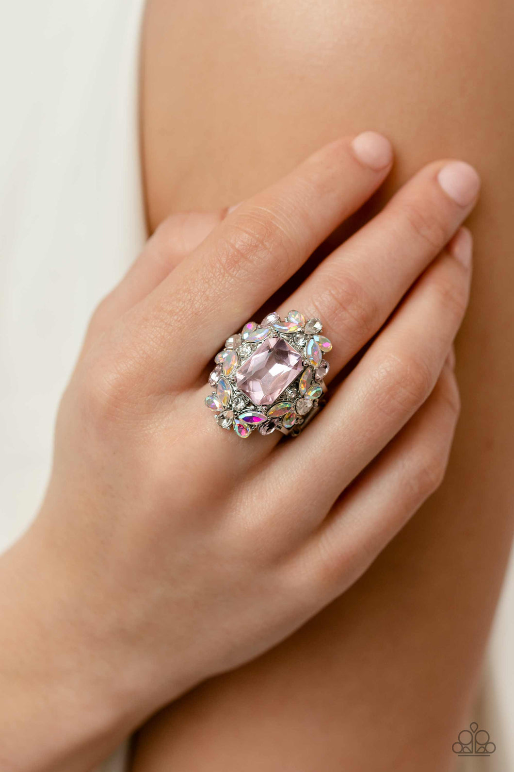 A faceted radiant-cut pink gem is pressed into an elaborate frame filled with blinding round, teardrop and marquise-cut gems in shades of white, pink, and iridescent for a blingy statement atop the finger. Features a stretchy band for a flexible fit. Due to its prismatic palette, color may vary.  Sold as one individual ring.