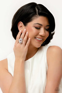 A faceted radiant-cut pink gem is pressed into an elaborate frame filled with blinding round, teardrop and marquise-cut gems in shades of white, pink, and iridescent for a blingy statement atop the finger. Features a stretchy band for a flexible fit. Due to its prismatic palette, color may vary.  Sold as one individual ring.