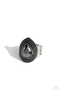 A faceted hematite teardrop gem is nestled inside a silver teardrop frame radiating with studded, layered textures, resulting in an edgy centerpiece atop the finger. Features a stretchy band for a flexible fit. Sold as one individual ring.