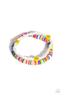 Hot pink, blue, white, and yellow clay discs combine with a strand of white seed beads to provide a vibrant pop of color along the wrist. Sporadically dotted in the high-sheen seed bead strand, yellow smiley face beads rest for a youthful finish on elastic stretchy bands.  Sold as one set of two bracelets.
