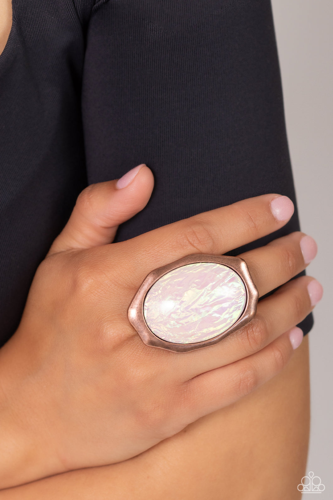 Featuring a refracted shimmer, an oversized oval-cut, opalescent white gem sparkles from an asymmetrical copper frame for an edgy statement piece atop the finger. Features a stretchy band for a flexible fit.  Sold as one individual ring.