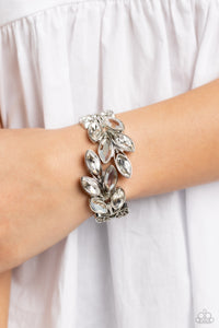 White and clear marquise-cut gems blossom from an array of silver marquise frames embossed in leafy filigree and tactile studs. Each frame interlocks around the wrist in a whimsical pattern to create a laurel-inspired design. Features a hinged closure.  Sold as one individual bracelet.