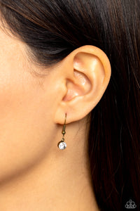 Clear rhinestone hanging from a brass fish hook earring.