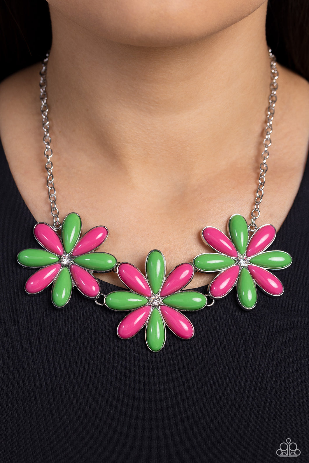 Dotted with white rhinestone centers, an elongated assortment of Classic Green and Pink Peacock beaded flowers link below the collar for a playful pop of color. Features an adjustable clasp closure.  Sold as one individual necklace. Includes one pair of matching earrings.