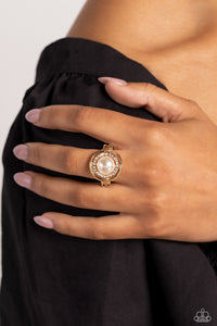 A slightly warped gold hoop encircles a glossy white pearl atop a dainty gold band. A daintier warped gold hoop, encrusted with white rhinestones, curls around the pearl inside the larger gold hoop for a touch of glitz to the sophisticated centerpiece. Features a dainty stretchy band for a flexible fit.  Sold as one individual ring.