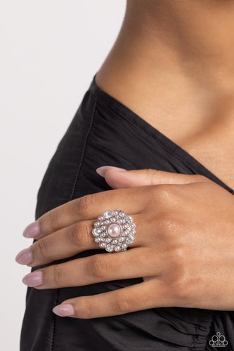An explosion of white gems and dainty glossy baby pink pearls encircle a larger baby pink pearl center, creating a glamorous silver centerpiece atop the finger. Features a stretchy band for a flexible fit.  Sold as one individual ring.