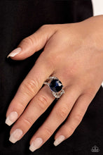 Load image into Gallery viewer, Glistening silver bars and white rhinestone-encrusted bands swirl across the finger, coalescing into an airy band. Featuring a regal faceted surface, a glittery blue gem is pressed into the center of the frame in silver-pronged fittings for a refined finish. Features a stretchy band for a flexible fit.  Sold as one individual ring.
