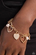 Load image into Gallery viewer, Glistening gold heart silhouettes, white potato pearls, and a white rhinestone-encrusted gold heart frame dangle from a classic gold chain link around the wrist, resulting in a romantic fringe. Features an adjustable clasp closure.  Sold as one individual bracelet,
