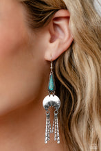 Load image into Gallery viewer, A turquoise stone pressed in a studded triangular fitting, and a silver floral-decorated half moon frame link into an earthy lure. A collection of daintily textured silver tassels in varying sizes swing from the bottom of the stacked frame for a whimsical finish. Earring attaches to a standard fishhook fitting. As the stone elements in this piece are natural, some color variation is normal.  Sold as one pair of earrings.
