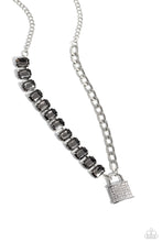 Load image into Gallery viewer, Infused on a classic silver chain, a strand of thick silver curb chain, and a collection of exaggerated, smoky radiant-cut gems in silver pronged fittings combine to create a collision of industrial color around the neckline. An oversized silver lock charm, embossed in white rhinestones, dangles from the gritty display for a touch of soft glitz to the design. Features an adjustable clasp closure.  Sold as one individual necklace. Includes one pair of matching earrings.

