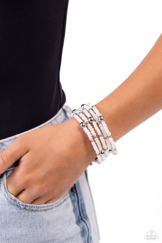 Pearly white seed beads, and various-sized silver accents are threaded along a coiled wire, creating a refined infinity wrap-style bracelet around the wrist. Sold as one individual bracelet