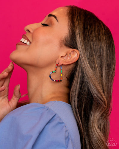 A simple silver hoop of silver curves around the ear into a heart-shaped frame. Featured on the heart frame, multicolored stripes alternate with the high-sheen finish of the silver for a lasting impression. Earring attaches to a standard post fitting. Hoop measures approximately 1 3/4