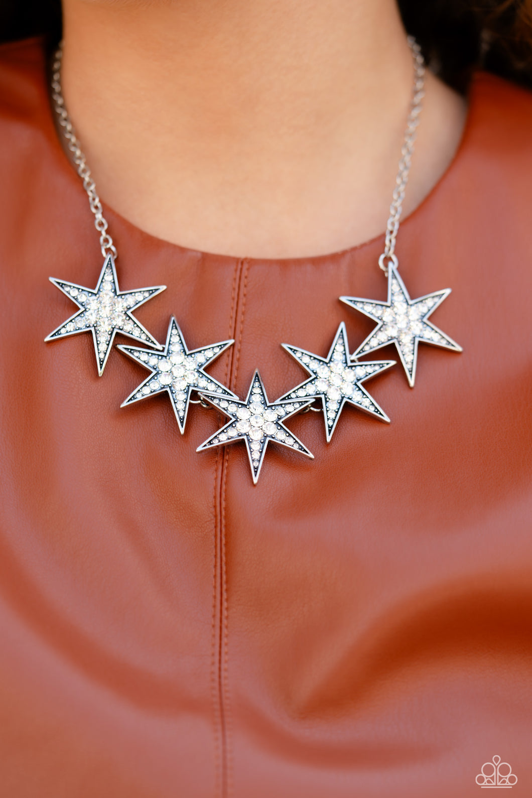 Dotted with various sizes of highly reflective white rhinestones, a stellar collection of 3D silver stars interlock from a dainty silver link chain for an out-of-this-world edgy fashion. Features an adjustable clasp closure.  Sold as one individual necklace. Includes one pair of matching earrings.