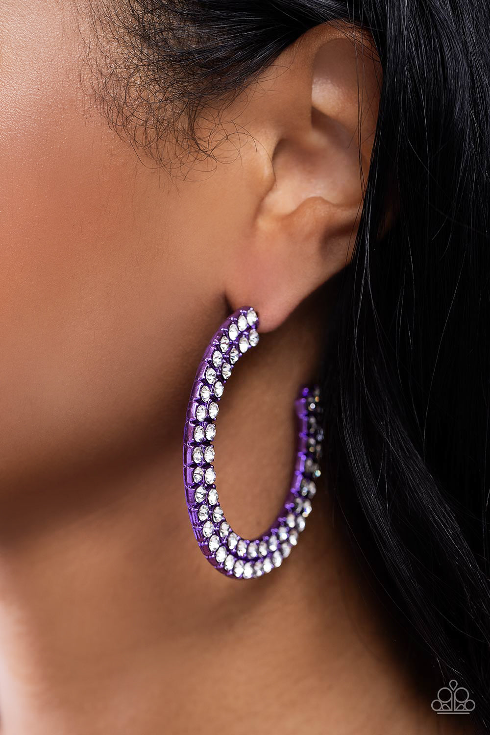 The outer curve of an oversized thick metallic purple hoop is encrusted in a staggered double row of dazzling white rhinestones for a flawless look. Earring attaches to a standard post fitting. Hoop measures approximately 2 1/4