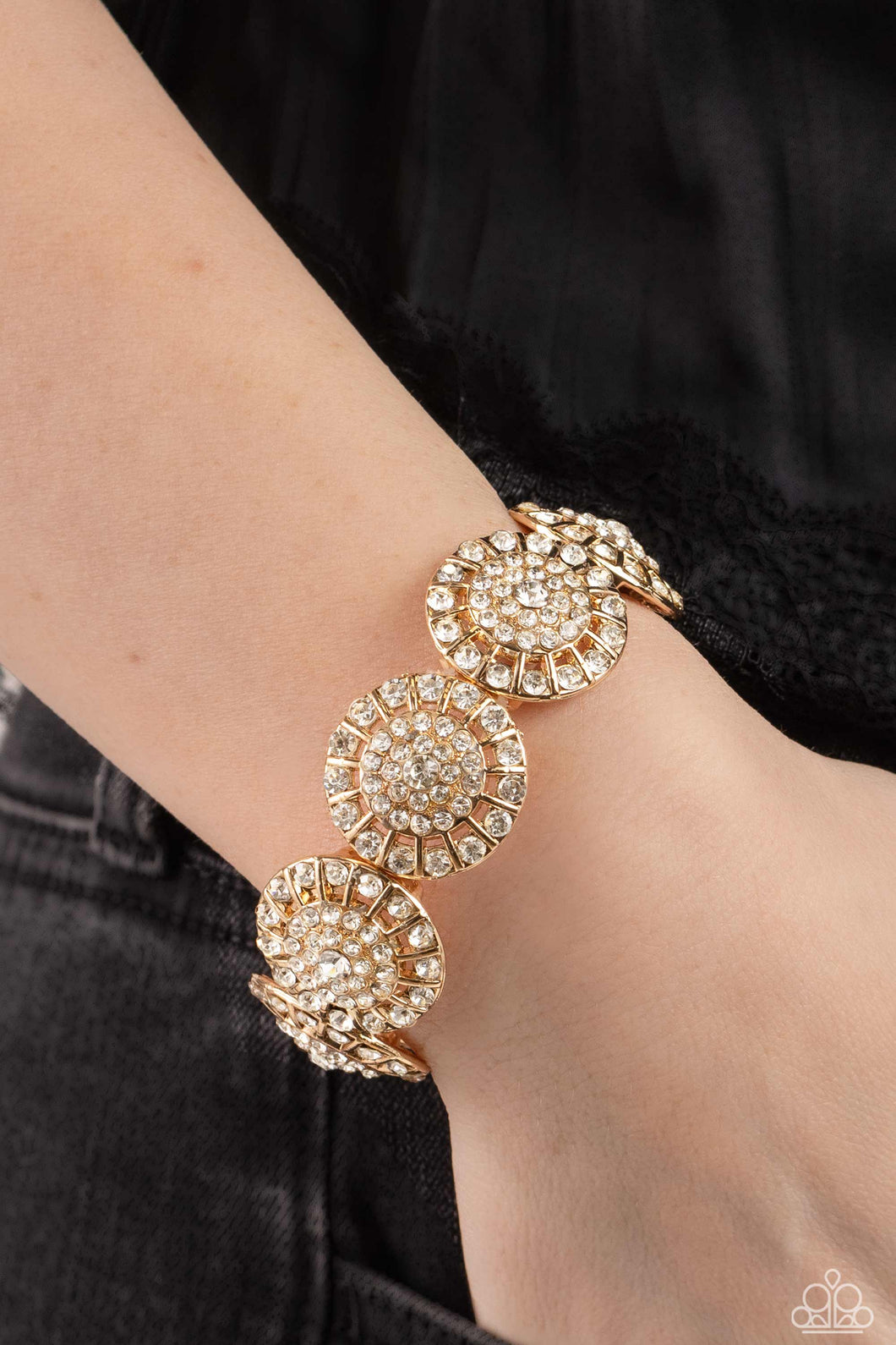 Featuring a wheel motif, concaved gold discs embossed in an explosion of white rhinestones slide along a stretchy band around the wrist for a hint of dazzling refinement.  Sold as one individual bracelet.