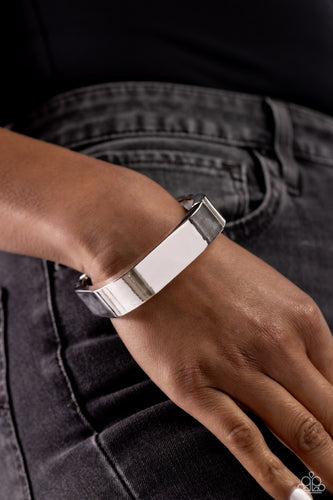Featuring a sleek, high-sheen finish, a thick silver cuff asymmetrically wraps around the wrist, creating a tilted square centerpiece for a monochromatic staple. Features a hinged closure.  Sold as one individual bracelet.