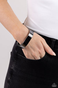 Featuring a sleek, high-sheen finish, a thick gunmetal cuff asymmetrically wraps around the wrist, creating a tilted square centerpiece for a monochromatic staple. Features a hinged closure. Sold as one individual bracelet.